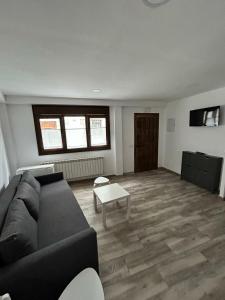 een woonkamer met een bank en een tafel bij Apartamentos El Calleral in Villahormes
