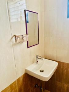 une salle de bains avec un lavabo blanc et un miroir dans l'établissement Shore and More - 7 Mins Walk to the Benaulim beach, à Benaulim