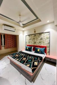 - une chambre dotée d'un grand lit avec des oreillers bleus et rouges dans l'établissement Shore and More - 7 Mins Walk to the Benaulim beach, à Benaulim