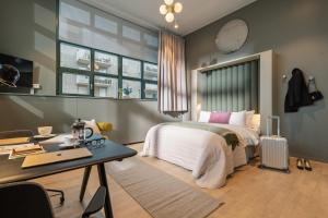 斯德哥尔摩Unity Hammarby Sjöstad - A Studio Hotel的带床、书桌和窗户的卧室