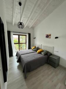 een slaapkamer met twee bedden en een groot raam bij Apartamentos El Calleral in Villahormes