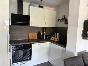 a kitchen with white cabinets and a stove top oven at Ruhrpott FeWo in Oberhausen