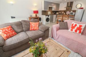 a living room with two couches and a kitchen at The Packing House in Penzance