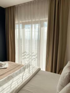 una camera da letto con un letto e una finestra con tende di NLux Nest a Kopaonik