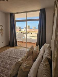 a living room with a couch and a large window at Apartamento vista al mar y Piscina en Playa Paraiso in Playa Paraiso