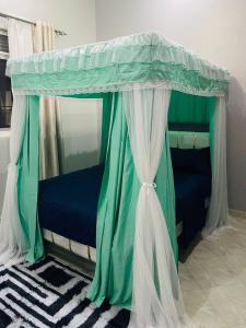 a bed with a canopy in a room at Hanso Furnished Apartments in Kampala