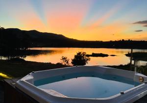 a bath tub sitting on the side of a lake at Hotel Chalé Capitólio in Capitólio