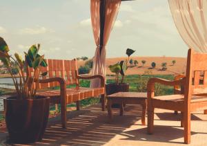 a patio with benches and a view of a field at Hotel Chalé Capitólio in Capitólio