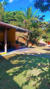 a house with a shadow of a tree on the grass at Pousada Casa da montanha in Sana