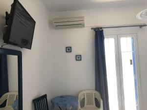a living room with a tv on the wall and a window at Marina 1 in Agios Ioannis