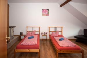 two beds in a living room with red sheets at Ferienwohnung in Xanten auf dem Moerenhof in Xanten