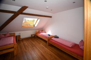 a attic room with two beds and a window at Ferienwohnung in Xanten auf dem Moerenhof in Xanten