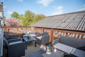 a patio with chairs and tables on a wooden deck at Ferienwohnung in Xanten auf dem Moerenhof in Xanten +29 photos