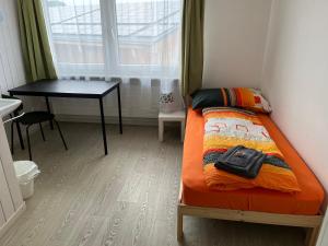 a small bedroom with a bed and a desk at 11 - Gästehaus Erika - Hundwil - Appenzellerland in Hundwil