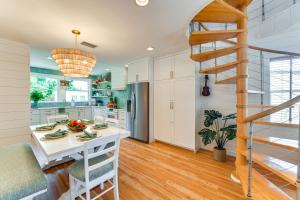 a kitchen with white cabinets and a spiral staircase at Walk to Gulf Luxe Luau-Themed Gem in Holmes Beach in Holmes Beach