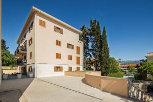 a large white building with trees in front of it at Mirela's golden luxury apartment in Split