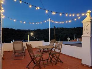 a table and chairs on a roof with lights at Blue Dragon River House in Odeleite