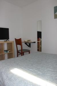 a bedroom with a bed and a table and chairs at Casa de huéspedes Villa de las Hortensias in Bustarviejo