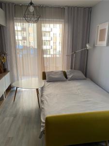 a small bedroom with a bed and a table at West Station Apartment in Warsaw