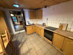 a kitchen with wooden cabinets and a stove top oven at Chalupa Maternovsko in Malá Skála