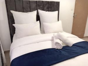 Elle comprend un grand lit avec des draps et des oreillers blancs. dans l'établissement Gold Crown One Bedroom Self-Catering Apartment With NetFlix & YouTube, à Johannesbourg