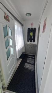 a hallway with a door to a room with a rug at Hello Tisza Vendégház in Tiszafüred