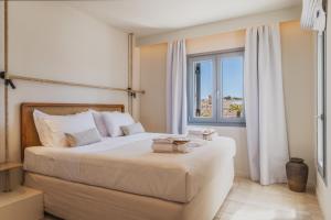 a bedroom with a large bed with a window at Adriana Luxury Villas in Adamas