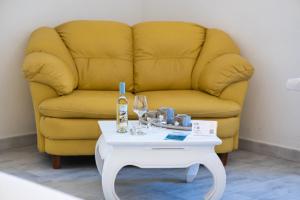 a yellow couch with a table with a bottle and glasses at Domo Libius - Casa Vacanze By Faendho - in Porto Torres