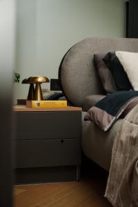 stolik nocny obok łóżka z lampką w obiekcie Apartament Family Green z garażem, klimatyzacją do 6 osób w Warszawie
