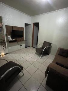 a living room with two chairs and a television at House da Cris in Pirassununga