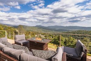 a patio with couches and a table with a fire pit at Yosemite Cloudline Ridge with HUGE views-hot tub-game room! in Oakhurst