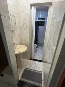 a bathroom with a sink and a shower with a toilet at House da Cris in Pirassununga