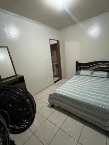 a bedroom with a bed and a chair in it at House da Cris in Pirassununga
