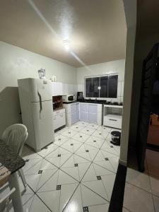 a kitchen with a refrigerator and a tile floor at House da Cris in Pirassununga