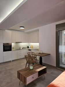 a living room with a table and a kitchen at Olive Ridge in Porto Rafti