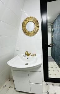 a white bathroom with a sink and a mirror at Wood Side in Tʼerjola