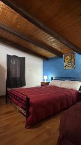 a large red bed in a room with a wooden ceiling at Il Rustico in Pozzillo