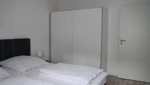 a white bedroom with a bed and a closet at Ferienwohnung Okerblick in Goslar