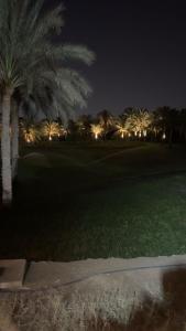 a golf course at night with palm trees and lights at Villa In 5th Settlement in Cairo
