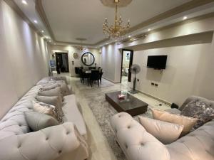 a living room with white couches and a dining room at Villa In 5th Settlement in Cairo