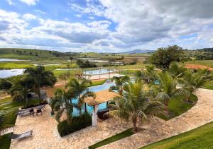 an aerial view of a resort with a pool and palm trees at Hotel Chalé Capitólio in Capitólio