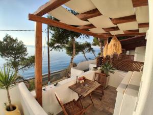 a patio with a table and a view of the ocean at MOUSELIS APARTMENTS in Kalymnos