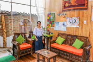 een vrouw in een kamer met stoelen bij OtavaloHuasi2 Quito in Quito