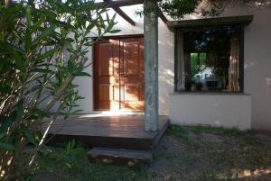 uma casa com um alpendre de madeira com uma porta de vidro em Casas de la Paloma - BUTIA em La Paloma