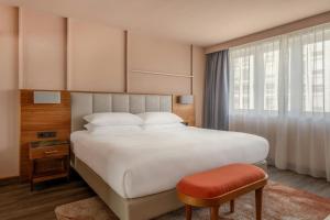 a bedroom with a large white bed and a stool at Vienna Marriott Hotel in Vienna