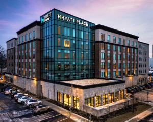 Un gran edificio con coches aparcados en un estacionamiento. en Hyatt Place Allentown - Lehigh Valley, en Allentown