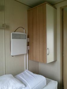 ein Zimmer mit einem Bett und einem Schrank mit Klimaanlage in der Unterkunft Kingfisher Horizon Elm 6 Berth Panel heated close to site shop in Ingoldmells