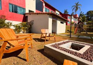 a park with two chairs and a bench and a playground at Hotel Chalé Capitólio in Capitólio