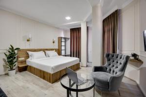 una stanza d'albergo con un letto e una sedia di Regraph Hotel a Tbilisi City