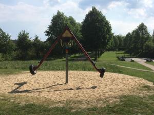 a swing set in the sand in a park at City Apartments Soltau in Soltau